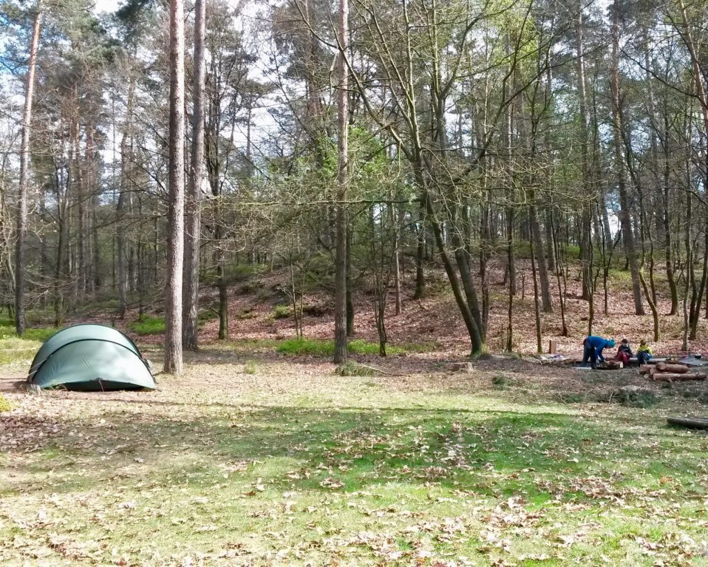 Tent in het bos met een vuurplaats